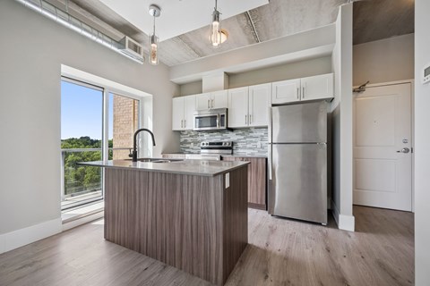 A kitchen with a large island and stainless steel appliances.