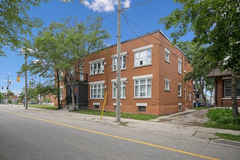 A red brick building with a black gate in front.