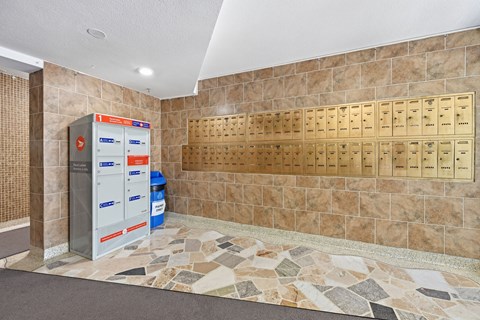A wall of mailboxes in front of a tiled wall.