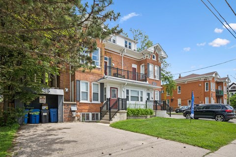 A large brick house with a black car parked in front.