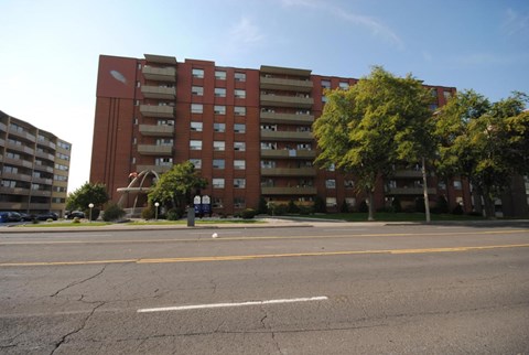 A large red brick building with a parking lot in front.