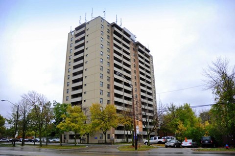 A tall building with a parking lot in front of it.
