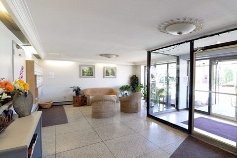 A hallway with a purple rug and a glass door.