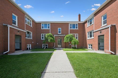 A red brick building with a walkway in front.