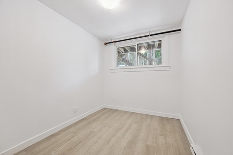 A room with a window and wooden flooring.