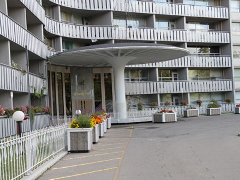 A white building with a white fence and a white canopy.