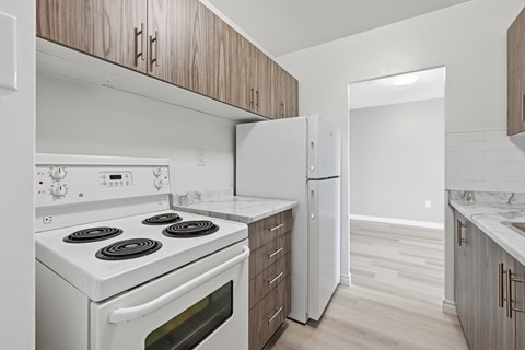 A white stove and oven in a kitchen with wooden cabinets.