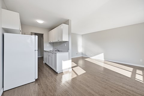 A kitchen with white appliances and cabinets is shown.