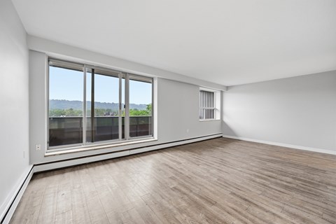 A room with a large window and wooden flooring.