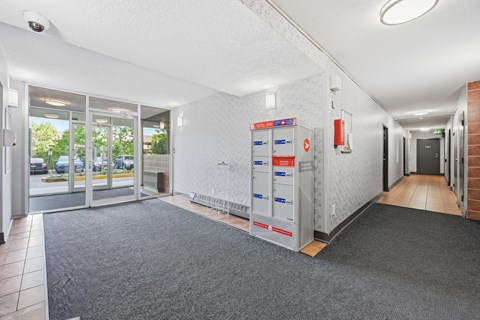 A hallway with a grey carpet and a white ceiling.