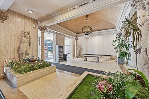 A room with a statue, a bench, and a planter with flowers.