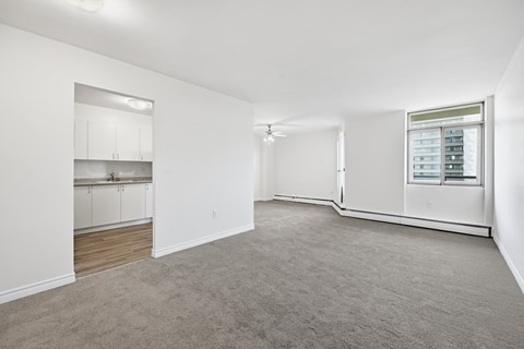 A spacious, empty room with a window and a built-in cabinet.