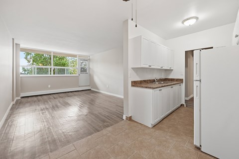 A kitchen with white cabinets and a countertop is shown.