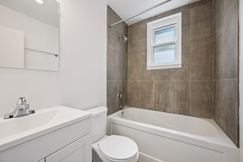 A bathroom with a tub, toilet, and sink.
