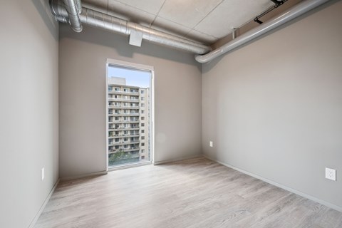 A room with a view of a building outside through a window.