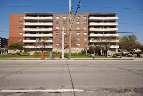 A large red and brown building with a parking lot in front.