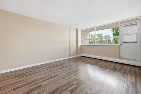 A room with wooden flooring and a white door.