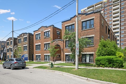 A street view of a residential area with a car parked on the side of the road.