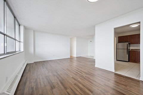 A spacious room with wooden floors and white walls.