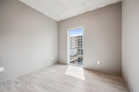 A room with a view of a building outside through a window.