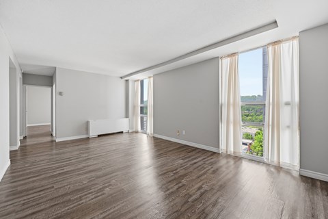 A large empty room with wooden floors and white walls.