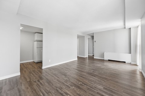 A room with wooden flooring and white walls.