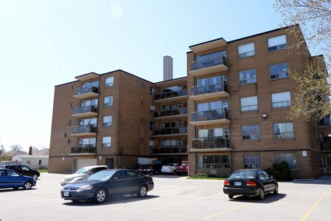 A parking lot with cars and apartment buildings.