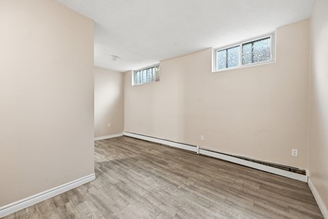 A room with a window and a wooden floor.