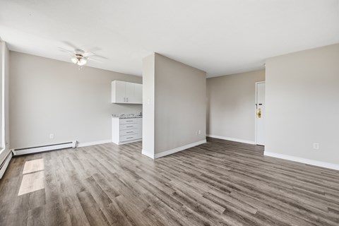 A room with wood flooring and a ceiling fan.