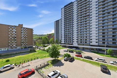 A parking lot with cars and apartment buildings in the background.