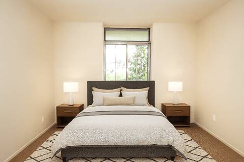 A bedroom with a large bed and two lamps.