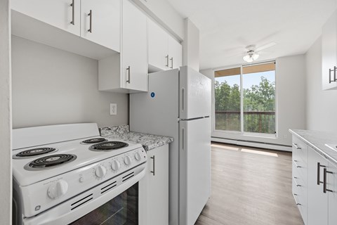 A white kitchen with a stove and refrigerator.