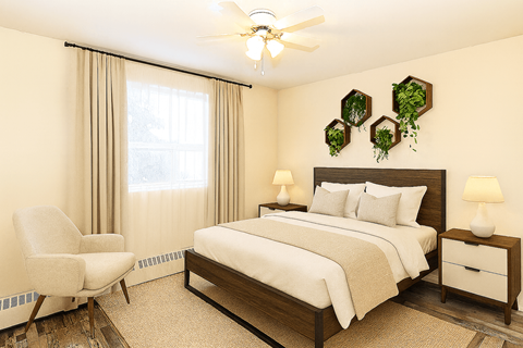 A bedroom with a bed, chair, and two lamps.