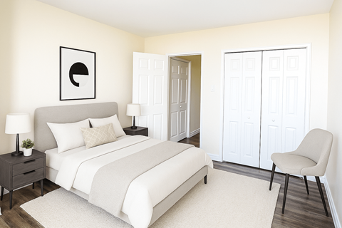 A bedroom with a bed, chair, and a wall art.