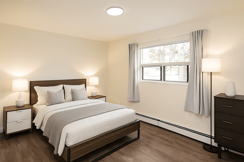 A bedroom with a large bed and two nightstands.