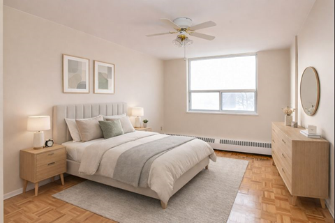 A bedroom with a bed, nightstand, and a window.