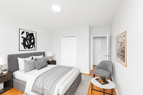 A bedroom with a bed, a chair, and a painting on the wall.