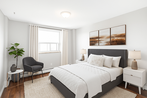 A bedroom with a large bed, a chair, and a painting on the wall.