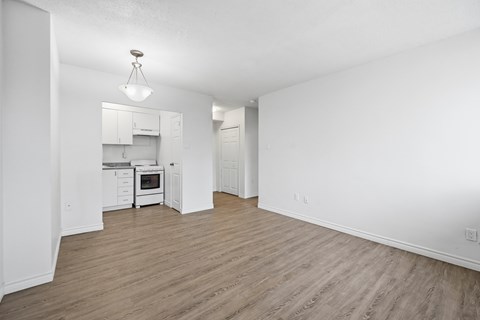 A kitchen with white cabinets and a wooden floor.