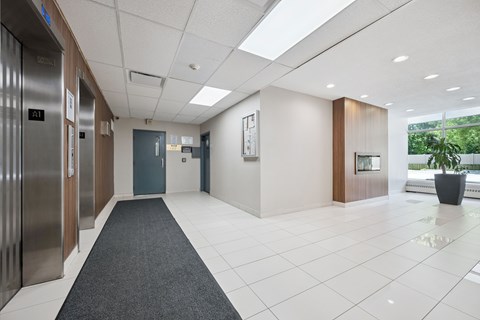 A hallway with a grey carpet and a blue door.