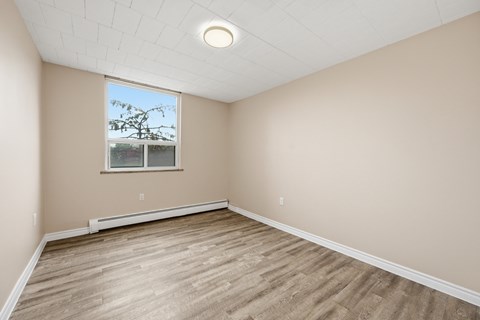 Empty room with wooden floor and a window.