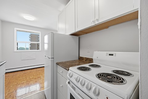 A white stove with a window above it in a kitchen.
