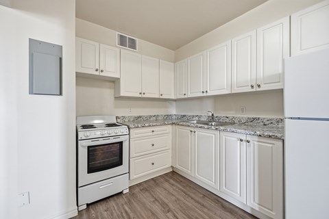 A white kitchen with a stove and cabinets.