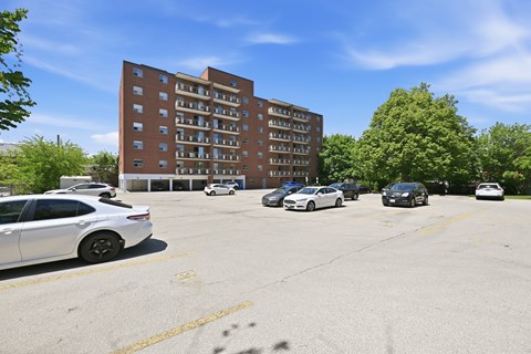 A parking lot with cars and a building in the background.