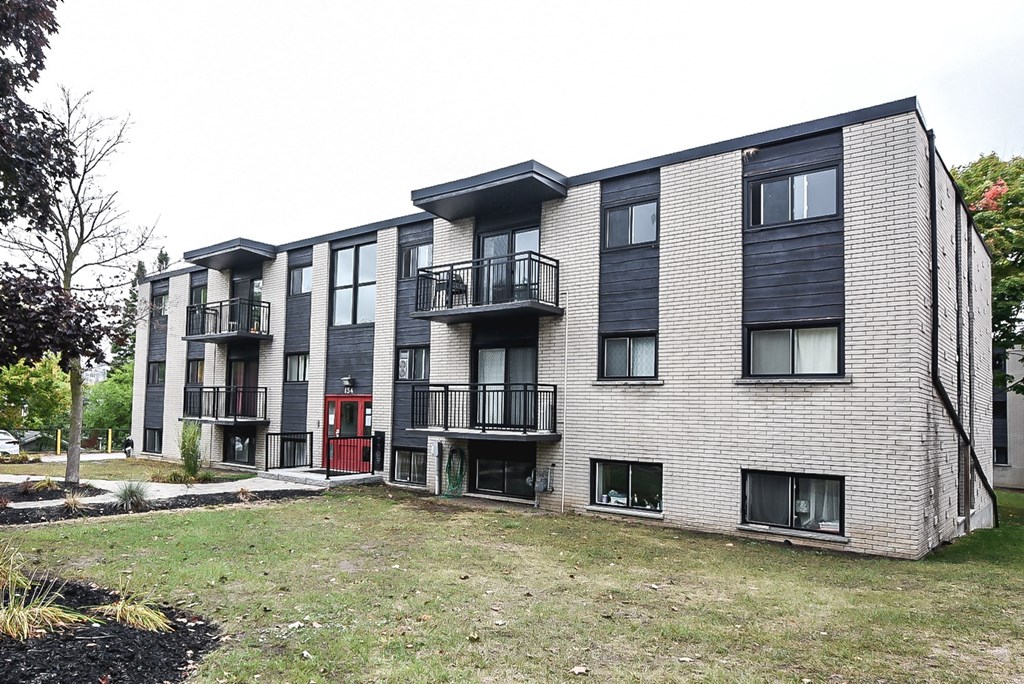 Apartment building with balconies and doors in front.