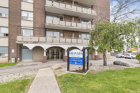 The entrance to a building named Granada with a blue sign in front.