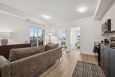 A living room with a brown couch and a wooden floor.