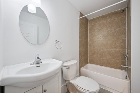 A bathroom with a toilet, sink, and bathtub.