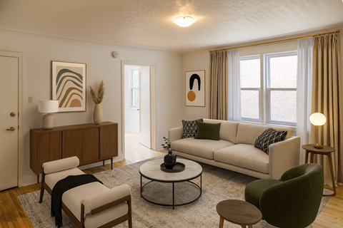 A living room with a white sofa, a green armchair, and a wooden coffee table.