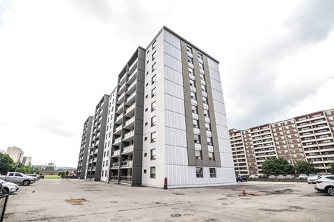 A large, modern building with a lot of windows and a parking lot in front.